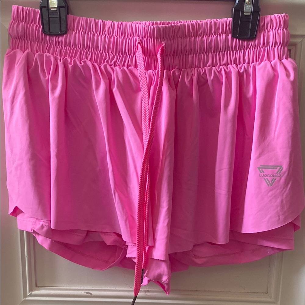 Vibrant Pink Athletic Shorts with Flowy Fabric and Ruffled Hem